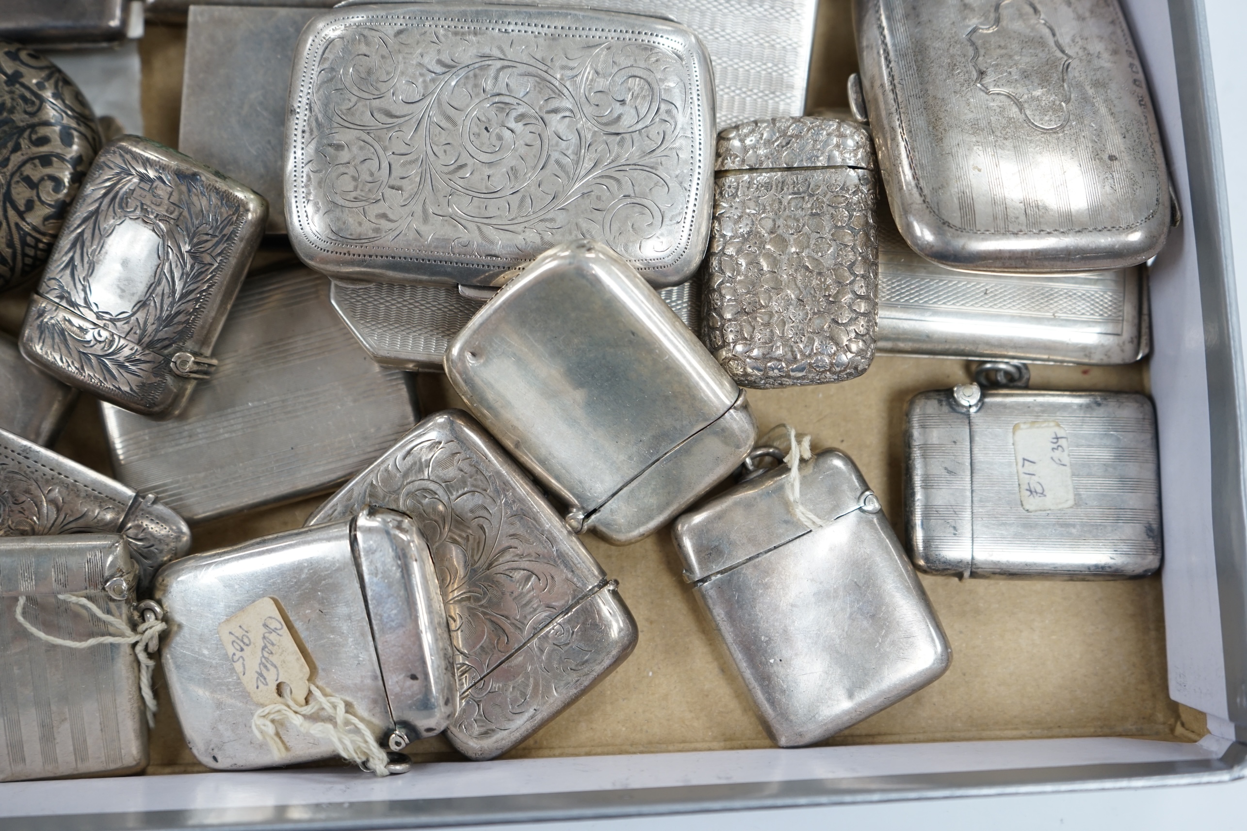 A collection of twenty four assorted silver vesta cases, eight cigarette cases, two match sleeves and a late 19th century Russian 84 zolotnik niello small tobacco box. Condition - poor to fair